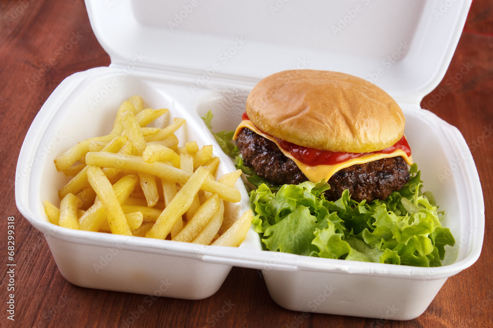 Burger and fries portion in takeout food box