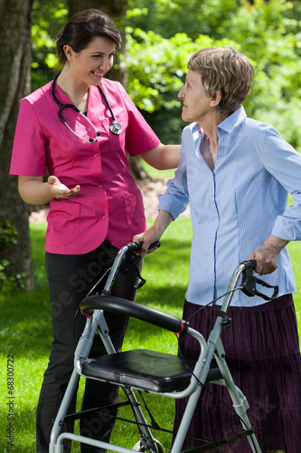 Nurse walking with a woman with a walker