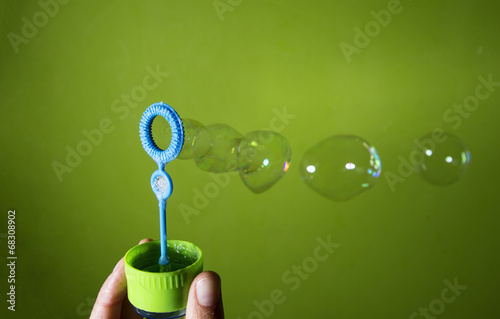 Bubble blower over green background