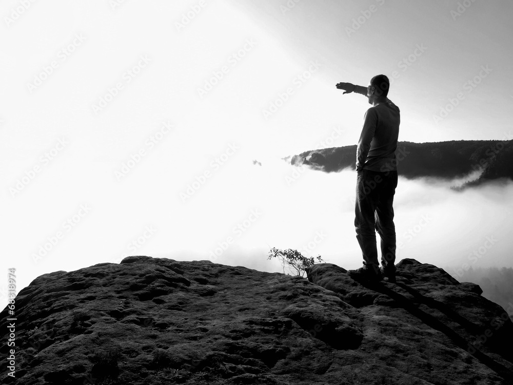 Obraz premium Man on rock watch over the morning misty valley to big Sun. 