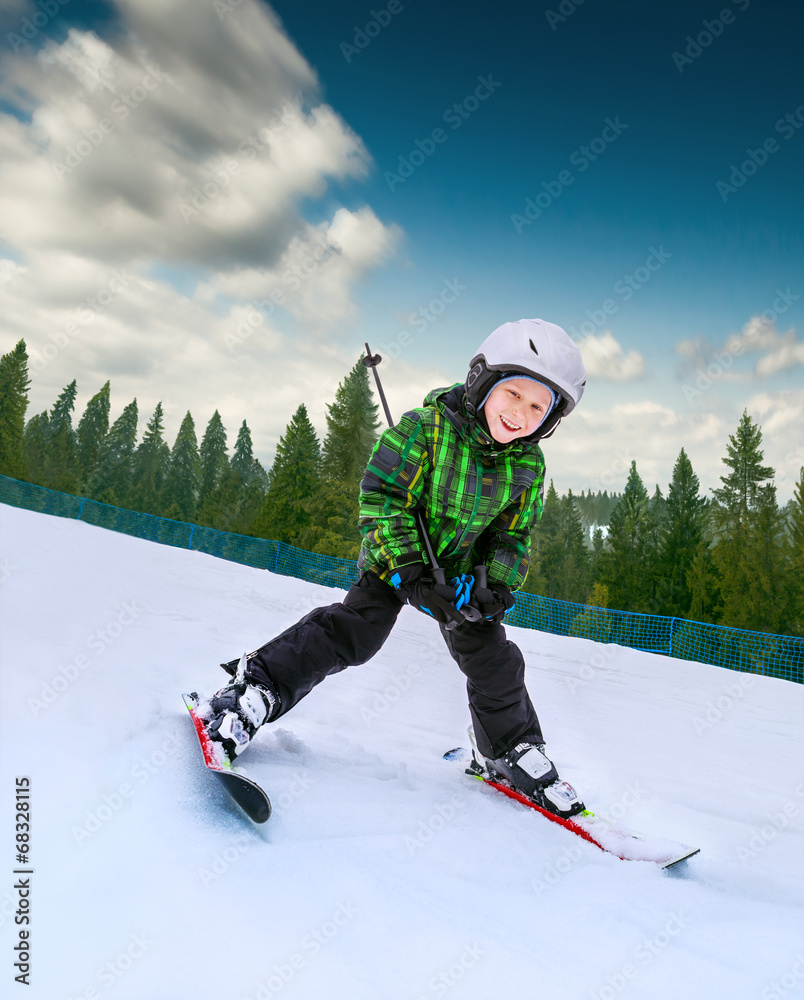Little skier going down from snowy hill