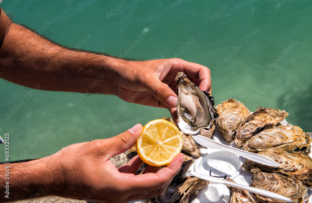 Fototapeta premium Man hands with lemon and oyster