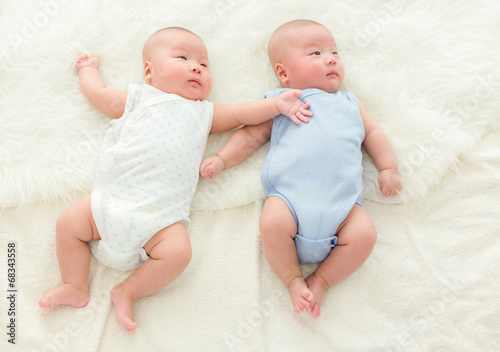 Twins baby lying on bed