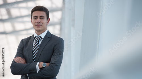 Obraz na plátně Businessman standing arms crossed