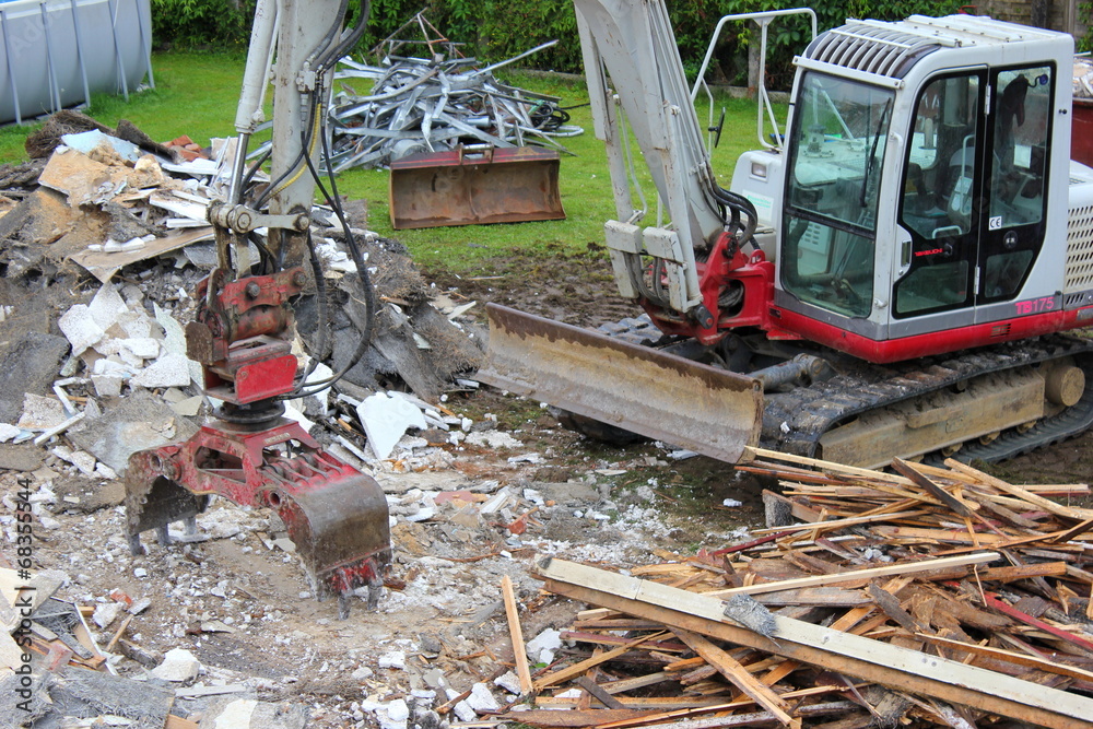 Fototapeta premium Ein Bagger beim Abbruch eines alten Hauses