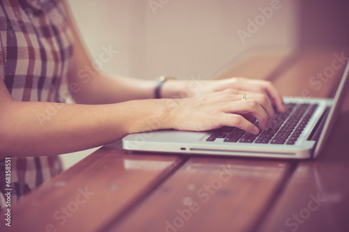Woman using laptop indoor.close-up hand
