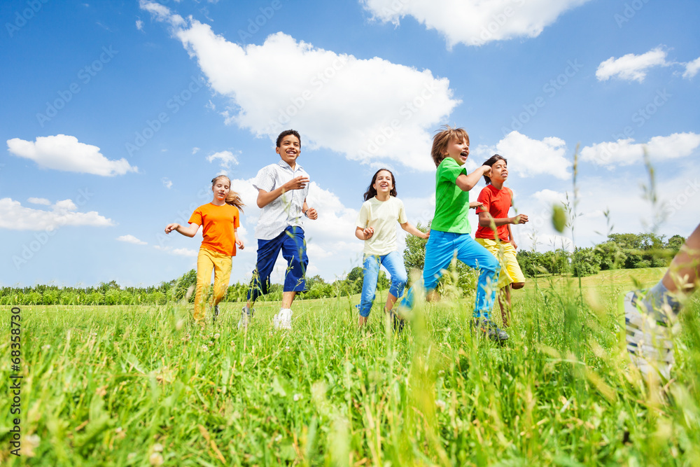 Positive kids playing and running in the field Positive kids playing and running in the field