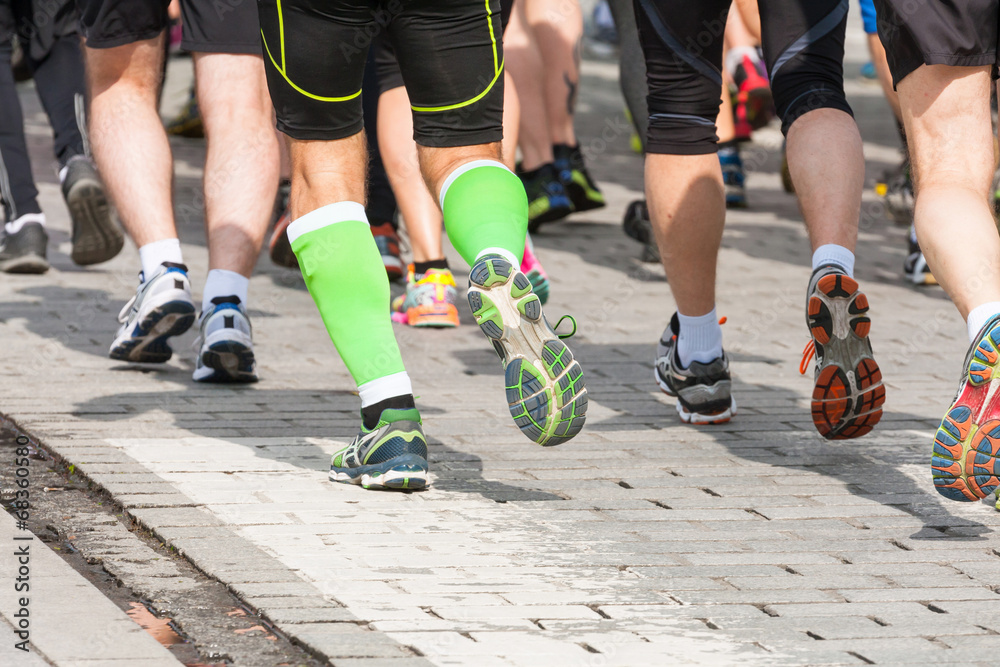 detail of the legs of runners at the start of a marathon race