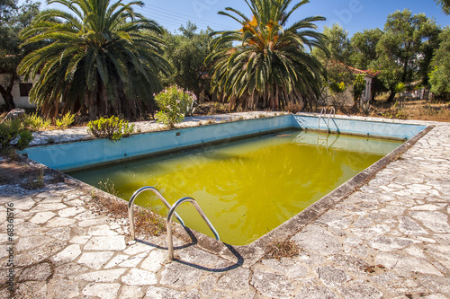 Putrid green water in abandoned swimming pool