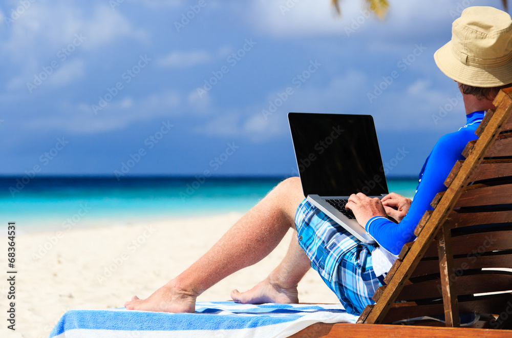 man with laptop on tropical vacation