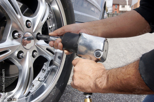 Auto mechanic changing car wheel