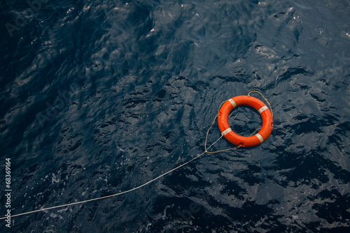 Obraz na plátně Lifebuoy in a stormy blue sea, Lifebuoy in blue sea