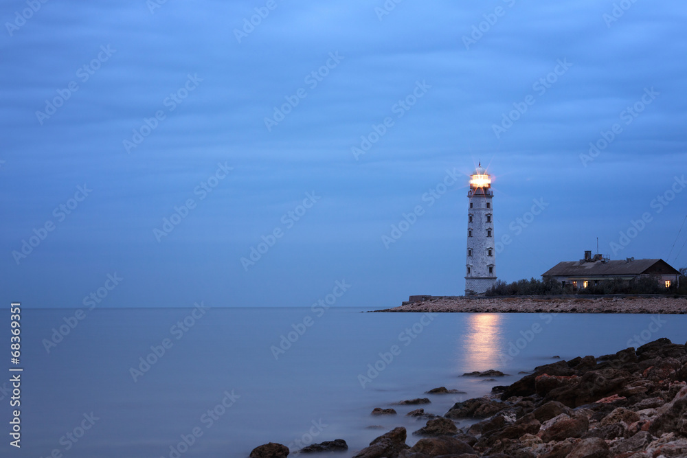Cloudy twilight seascape with lighthouse