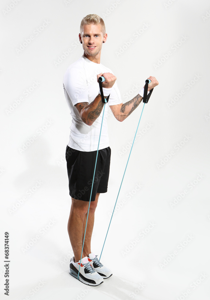 Obraz premium Ćwiczenia z gumami. Mężczyzna rozciąga mięśnie