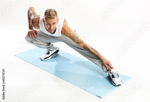 Ćwiczenia gimnastyczne na macie, mężczyzna ćwiczy jogę