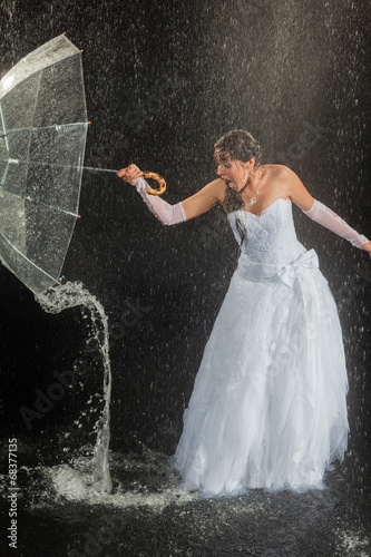 Bride sitting under rain