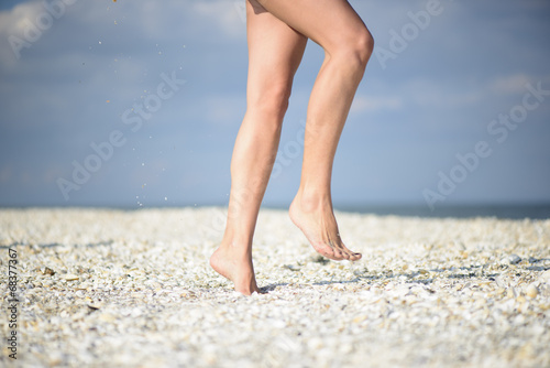 Closeup detail of female feet on a beach
