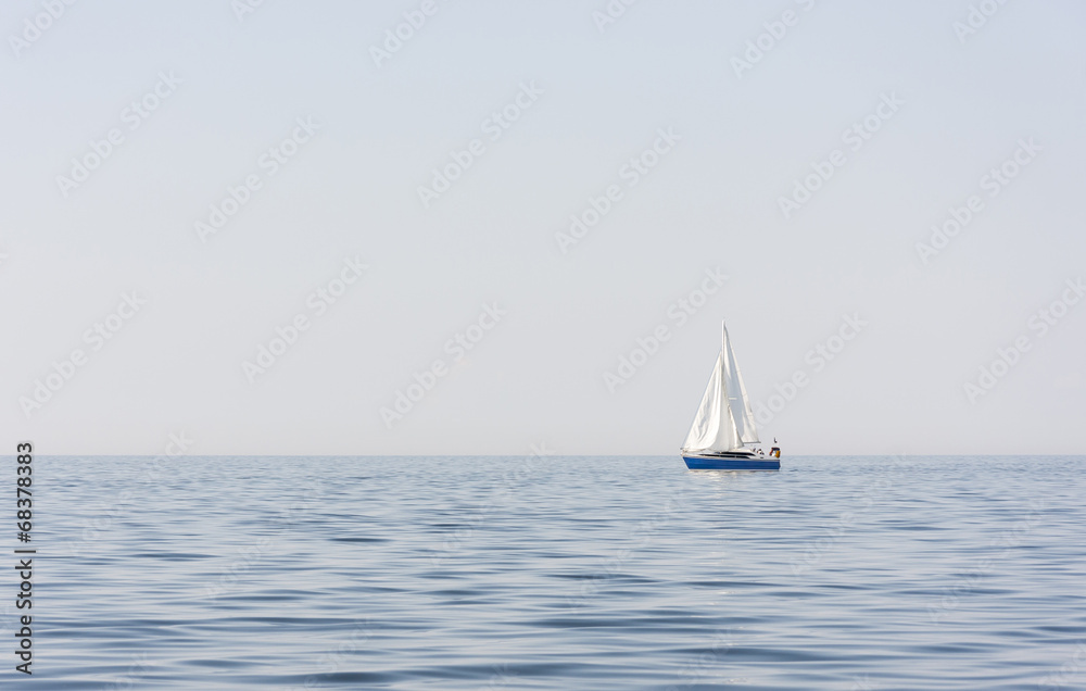 Obraz premium Blue sail boat at sea or ocean