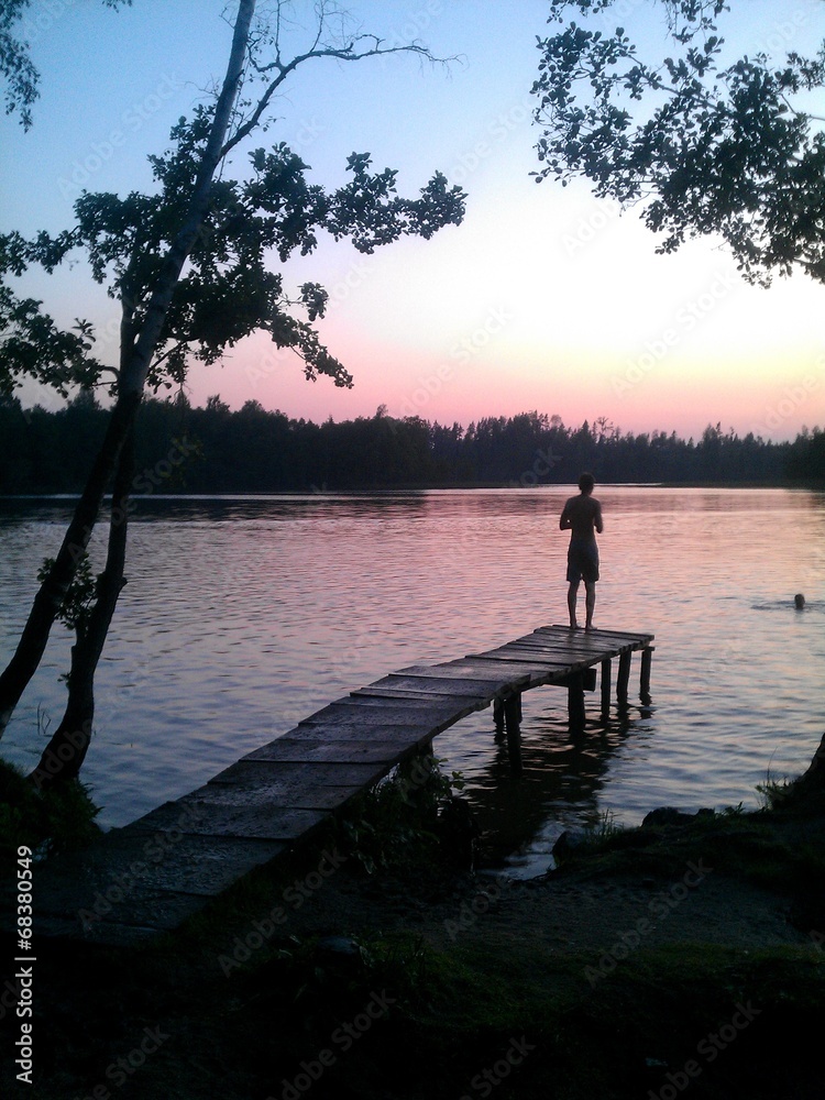 Junge springt vom Steg in den See
