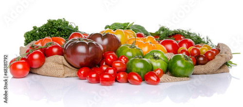 Composition of different varieties of tomatoes and herbs on a bu