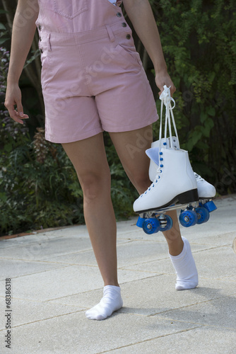 Teenage roller skater carrying her quad skates
