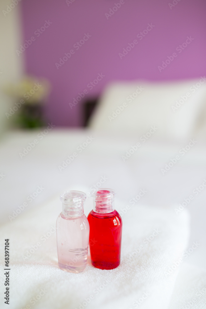 Freshly laundered white fluffy towels with shower gel in bedroom Freshly laundered white fluffy towels with shower gel in bedroom