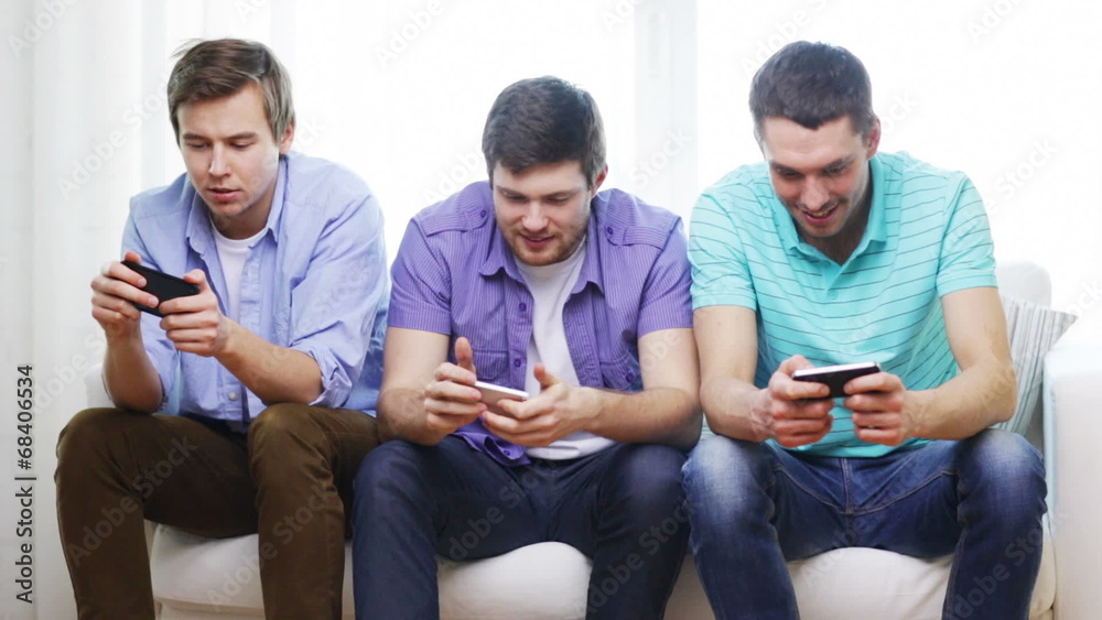 smiling friends with smartphones at home smiling friends with smartphones at home