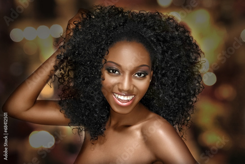 Young woman happy with curly hair on a bright background