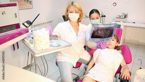 female dentist and nurse examine x-ray