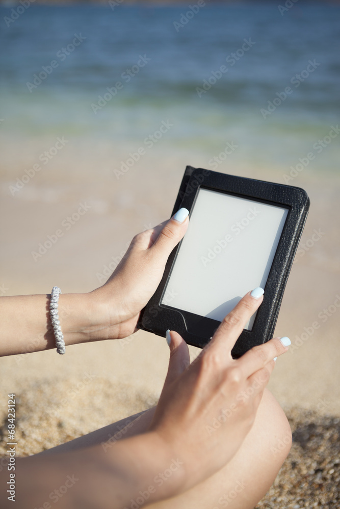 reading ebook reader on a beach 