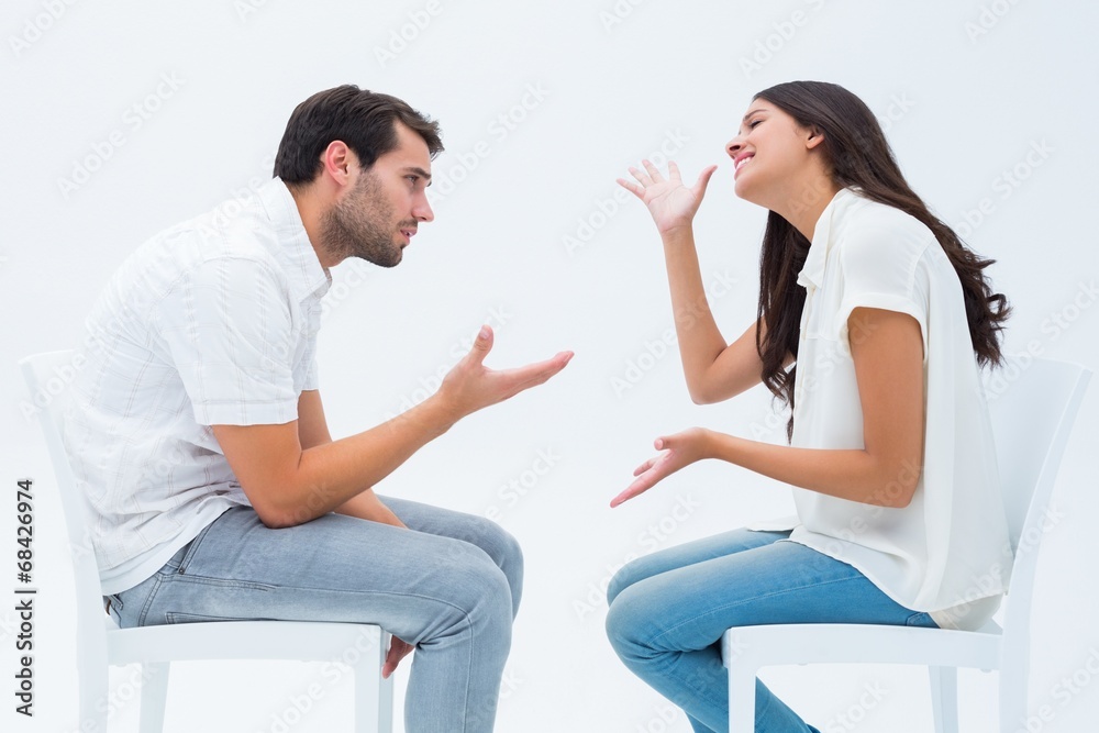 Couple sitting on chairs arguing Couple sitting on chairs arguing