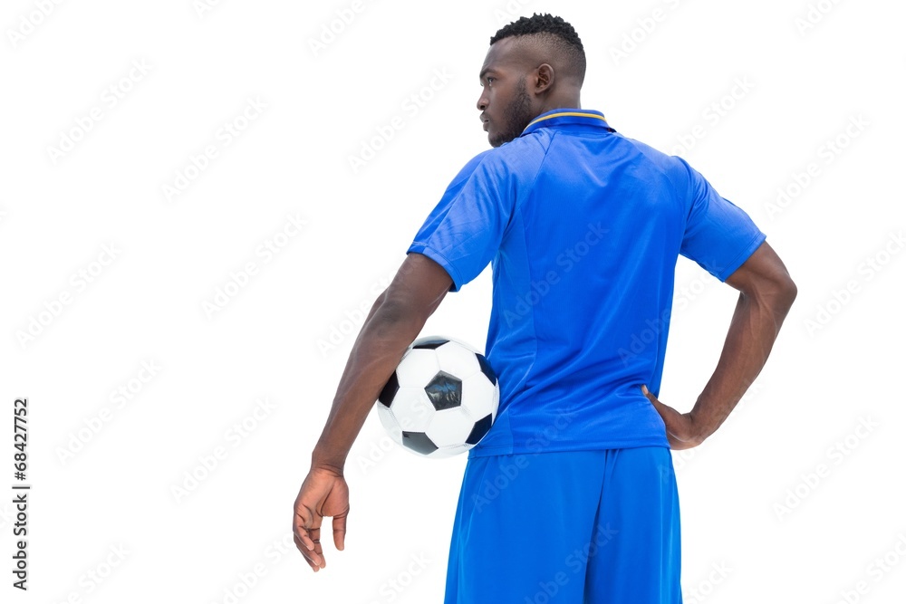 Football player in blue holding ball Football player in blue holding ball