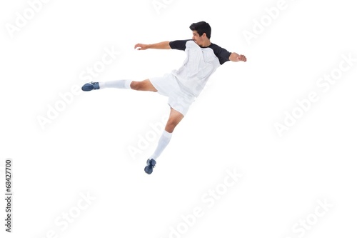 Football player in white kicking © WavebreakMediaMicro