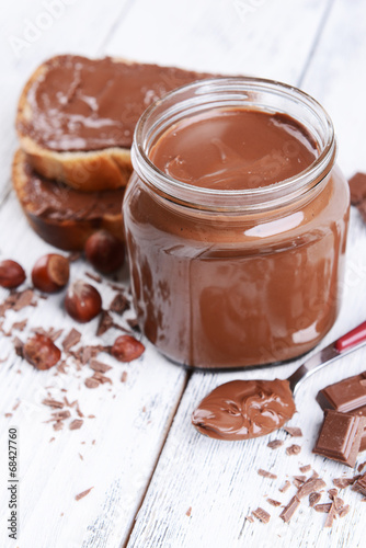 Sweet chocolate cream in jar on table close-up