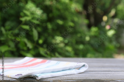 Wooden table with tablecloth, outdoors photo