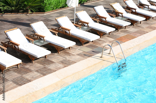 Canvas-taulu Lounge sunbeds near swimming pool