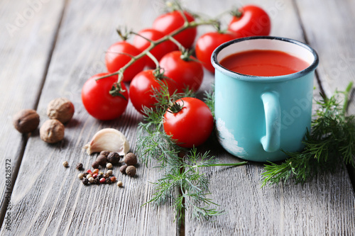 Homemade tomato juice in color mug, spices and fresh tomatoes