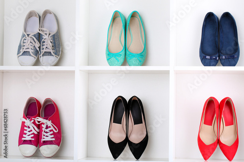 Colorful female shoes on wooden shelves