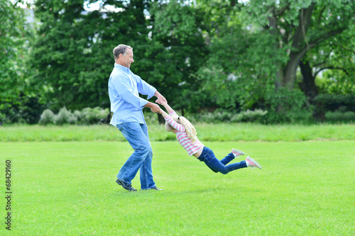 Playful father and daughter having fun in garden