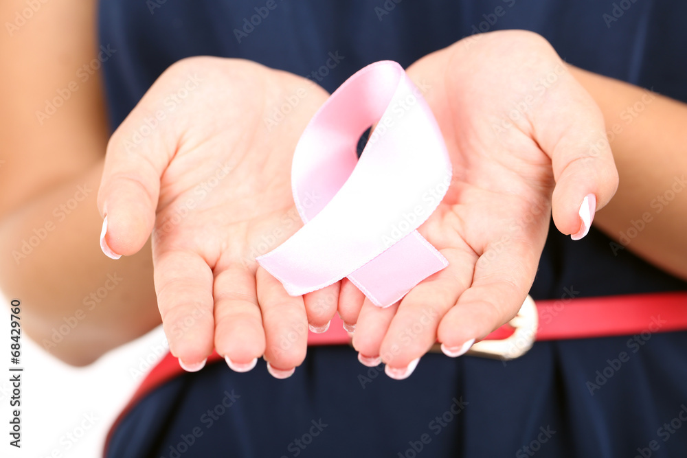 Fototapeta premium Woman with aids awareness pink ribbon in hands isolated on