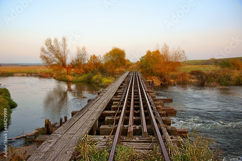 Autumn, bridge and railroad tracks on the river
