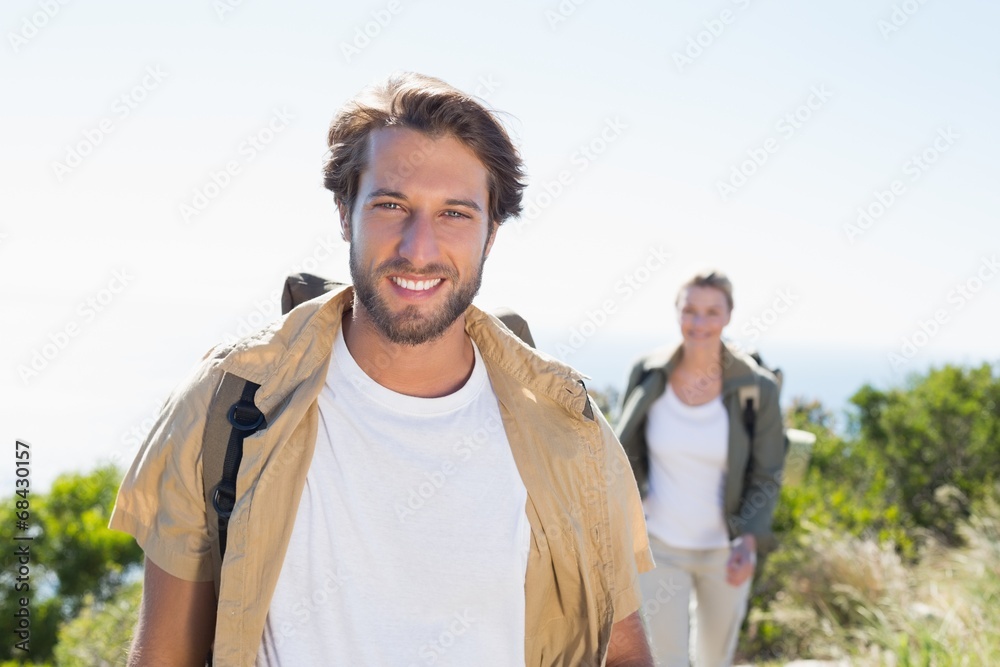 Hiking couple smiling at camera on mountain summit
