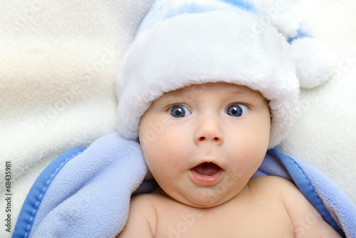 christmas cute baby boy, beautiful infant in Santa's hat and blu