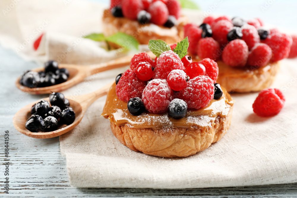 Sweet cakes with berries on table close-up Sweet cakes with berries on table close-up