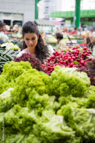 Pretty young woman buying vegetables on the market © BGStock72