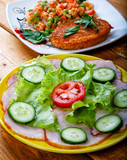 Vegetable salad and cutlet on a rural table