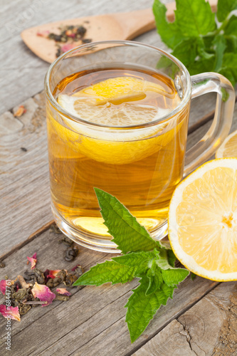 Green tea with lemon and mint on wooden table