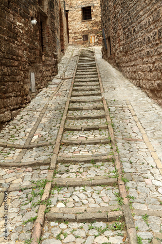 old narrow stone street with steps in little town Spello, Umbria