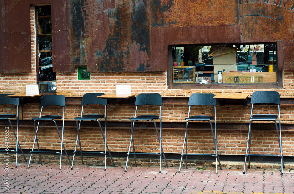Cafe chairs against brick wall