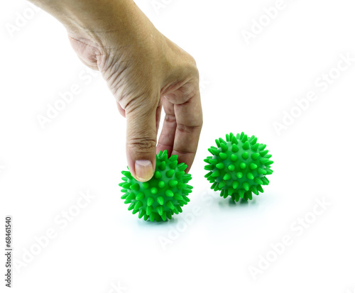 hand with Spiny plastic green massage ball isolated on white
